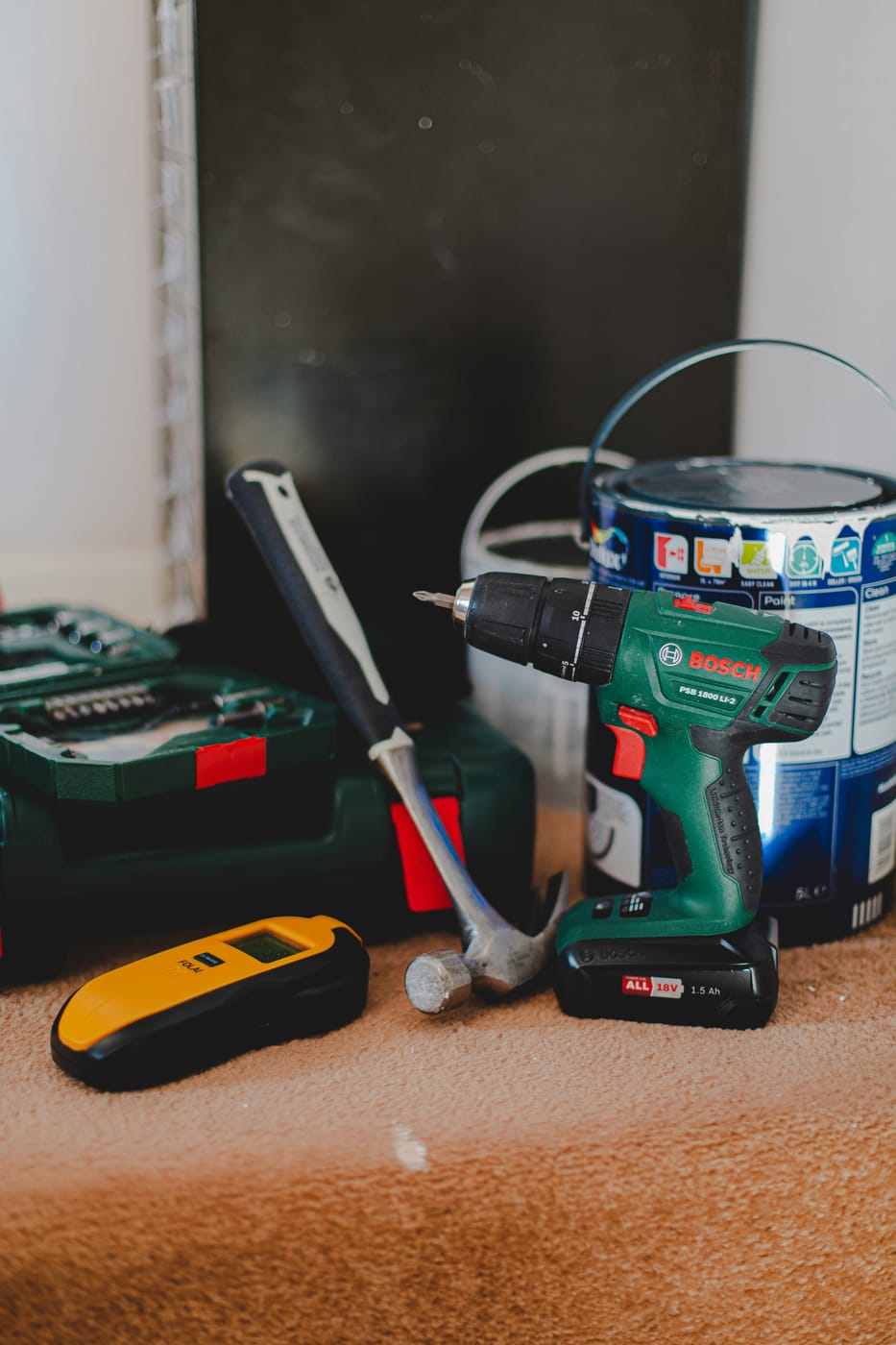 Drill, hammer and supplies staged indoors for point of sale violation repairs before a city inspection
